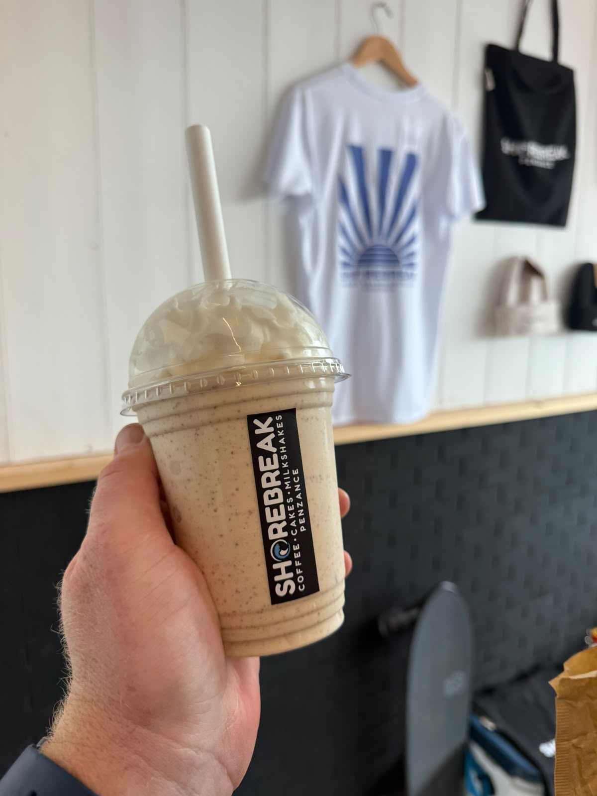 Milkshake held up in front of Shorebreak merchandise