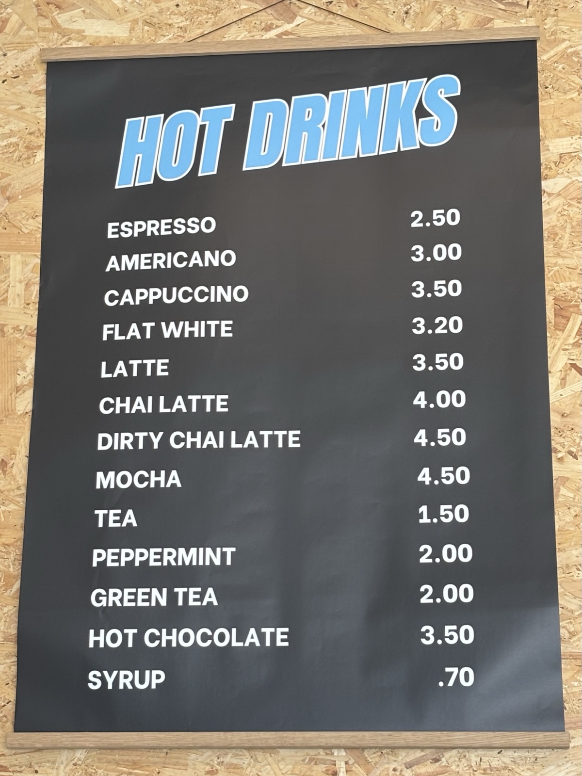 Hot drinks menu board — espresso, americano, cappuccino, flat white, latte, chai, mocha, teas and hot chocolate
